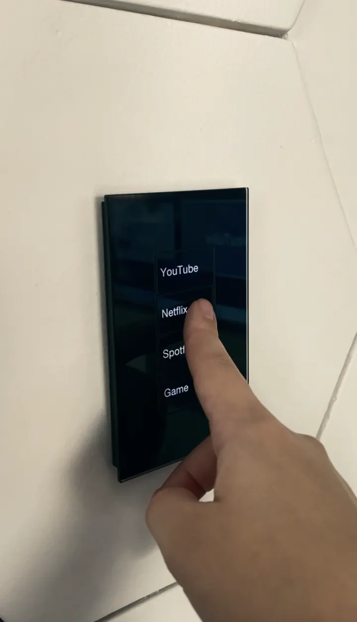 Keypad de parede em acabamento escuro sendo utilizado para controlar funções de um ambiente.