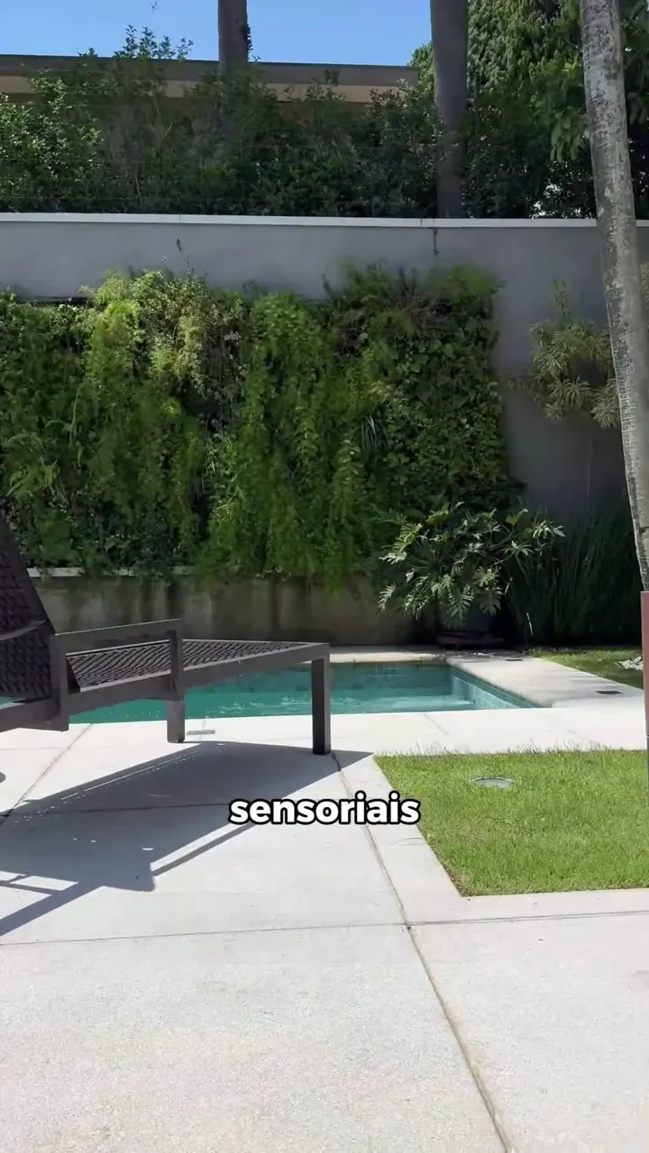 Área externa residencial com jardim e piscina preparada para integração de som ambiente.